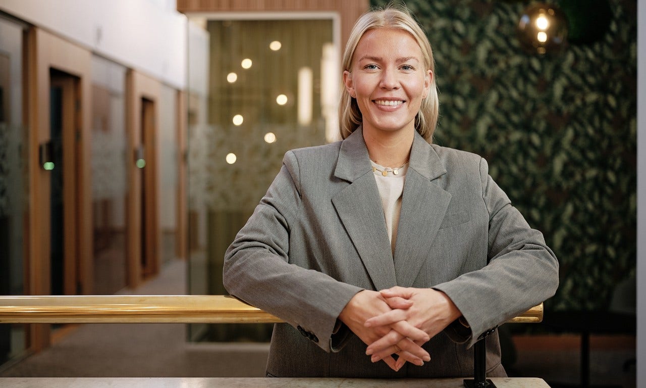 En leende kvinna som lutar sig på ett räcke