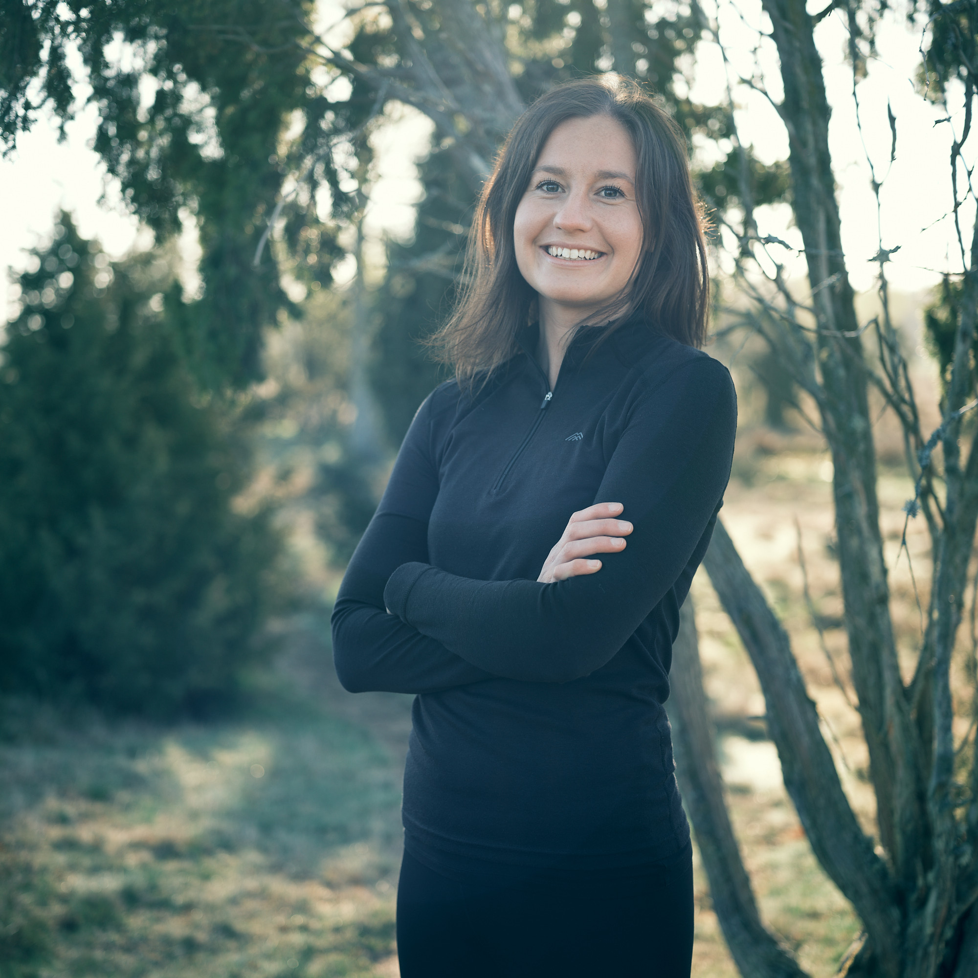 En kvinna som står utomhus med sina armar i kors