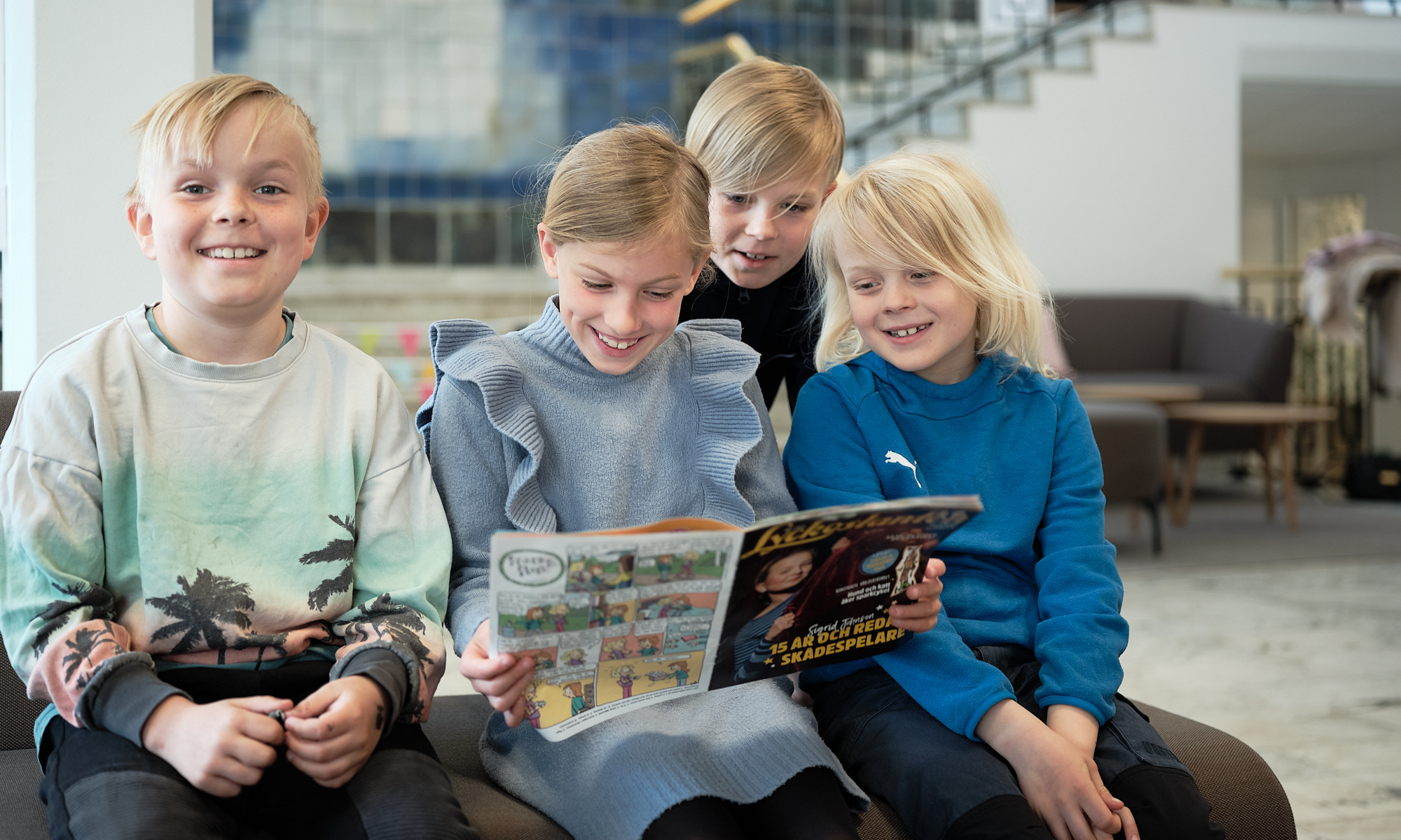 Fyra barn som läser en tidning tillsammans
